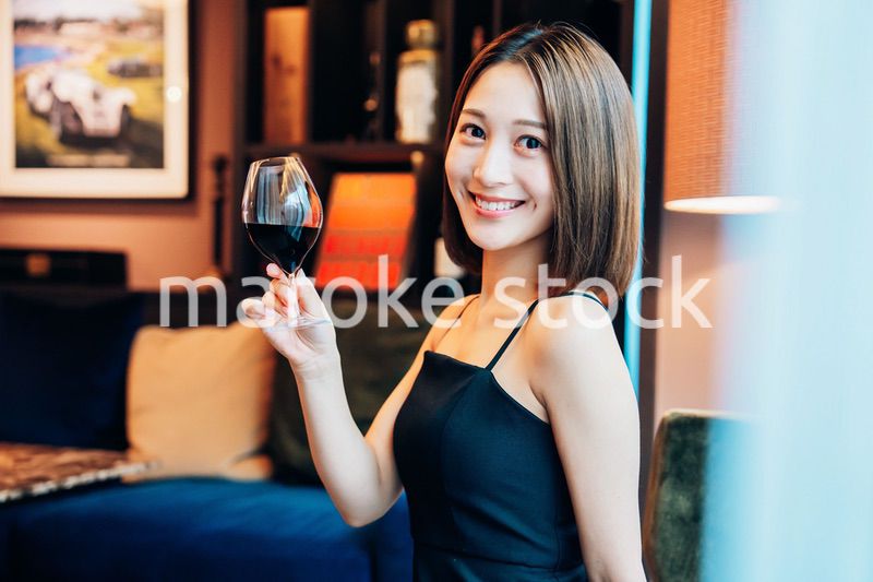 ラグジュアリーな雰囲気のお店で赤ワインを飲む若い女性