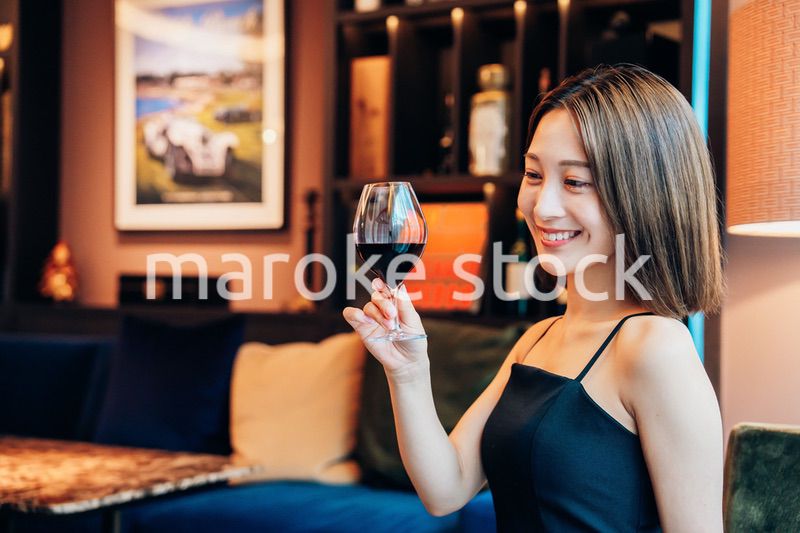 ラグジュアリーな雰囲気のお店で赤ワインを飲む若い女性