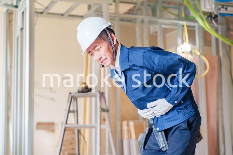 現場で腹痛に苦しむ男性の大工