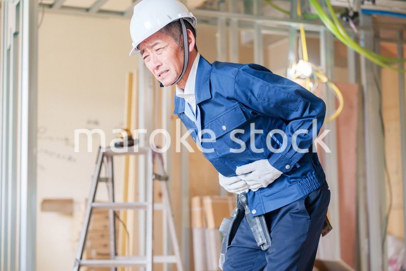 現場で腹痛に苦しむ男性の大工