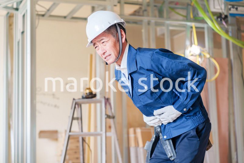 現場で腹痛に苦しむ男性の大工