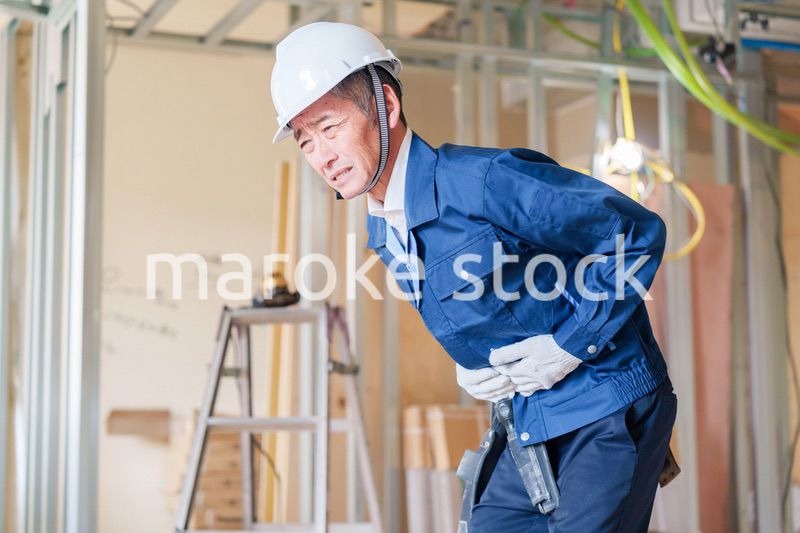 現場で腹痛に苦しむ男性の大工