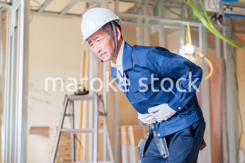 現場で腹痛に苦しむ男性の大工