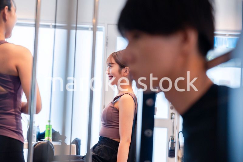 ジムのマシーンでトレーニングをする人