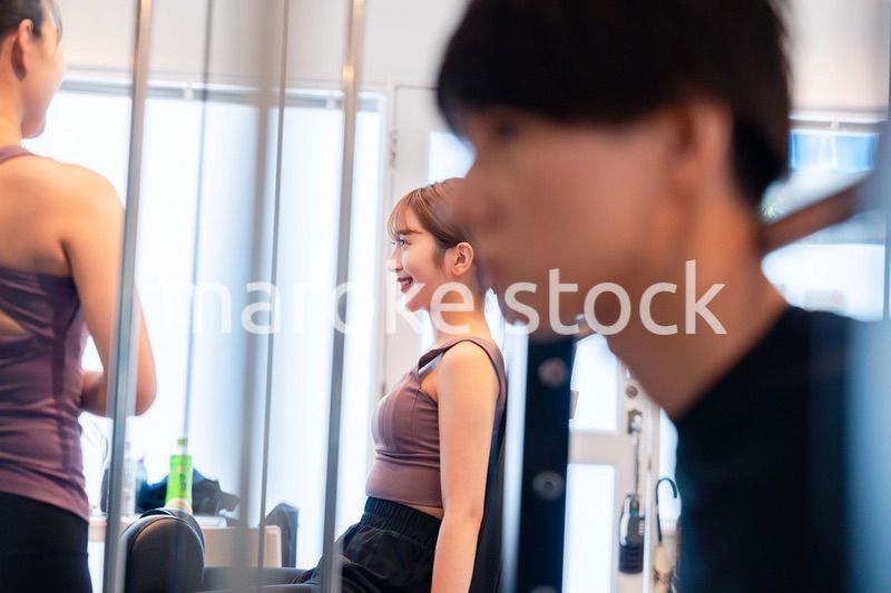 ジムのマシーンでトレーニングをする人