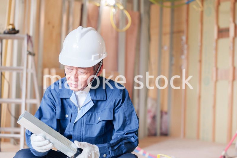 建設現場で軽量鉄骨の確認をする男性の職人