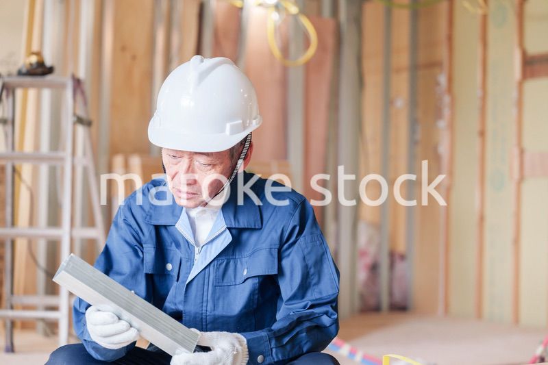 建設現場で軽量鉄骨の確認をする男性の職人
