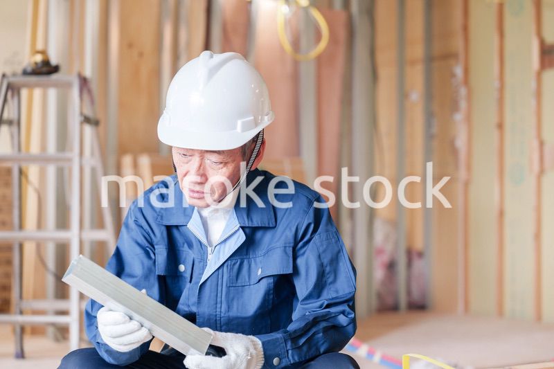 建設現場で軽量鉄骨の確認をする男性の職人