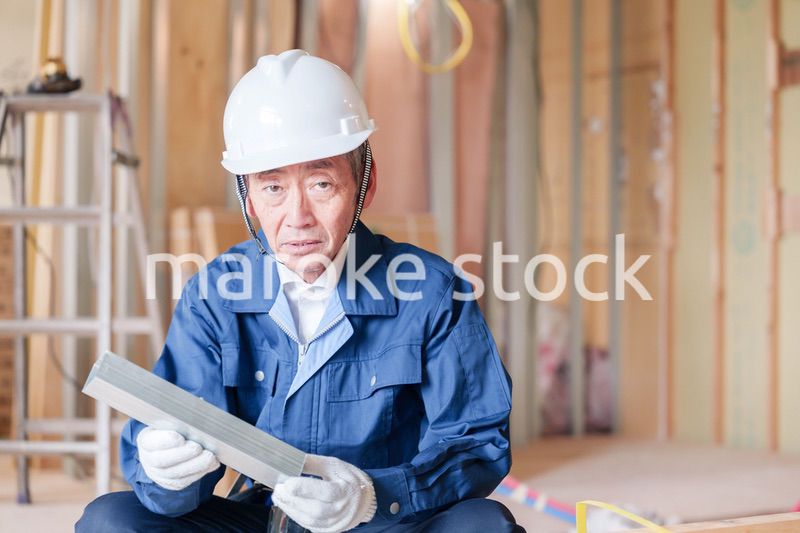 建設現場で軽量鉄骨の確認をする男性の職人