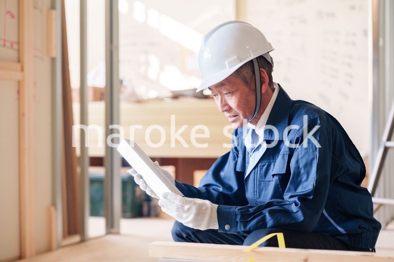 建設現場で軽量鉄骨の確認をする男性の職人