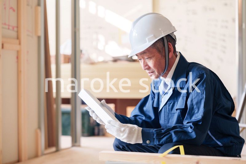 建設現場で軽量鉄骨の確認をする男性の職人