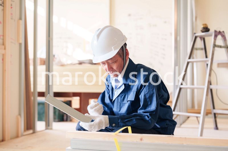 建設現場で軽量鉄骨の確認をする男性の職人
