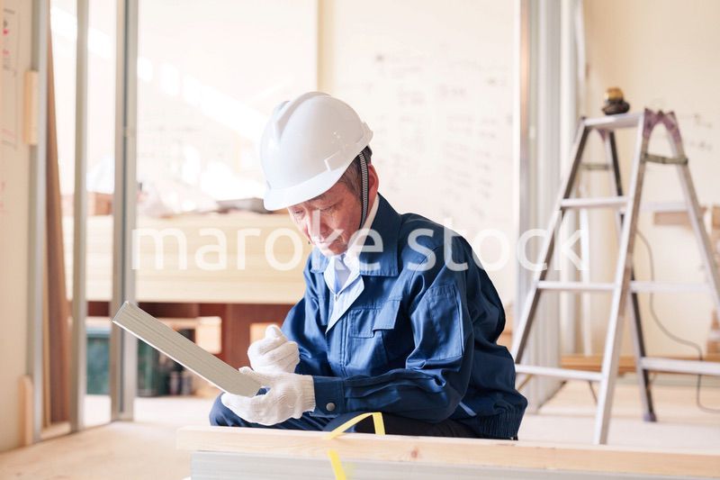 建設現場で軽量鉄骨の確認をする男性の職人