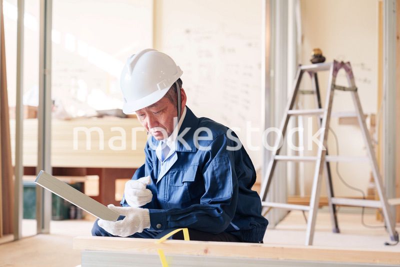 建設現場で軽量鉄骨の確認をする男性の職人