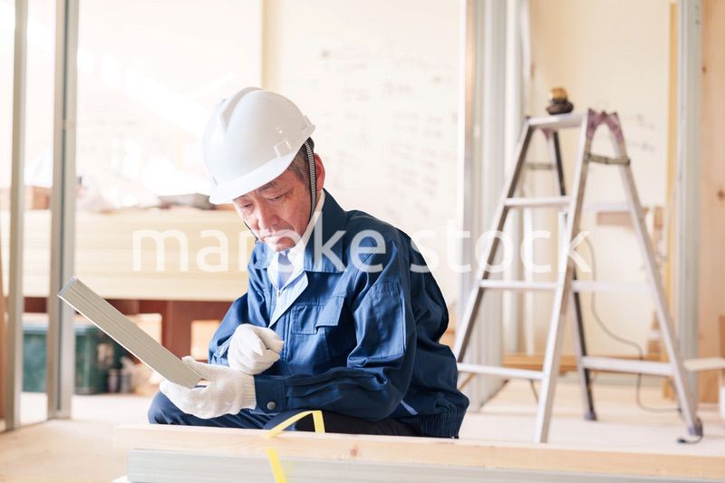 建設現場で軽量鉄骨の確認をする男性の職人