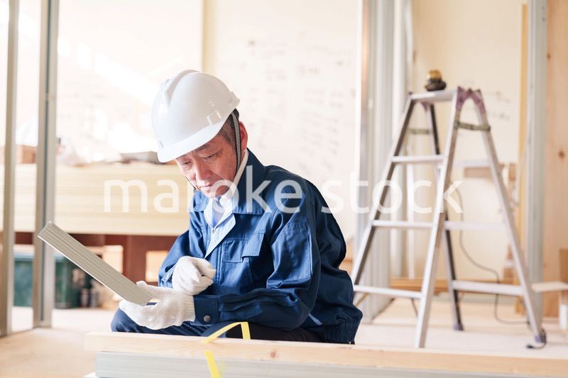 建設現場で軽量鉄骨の確認をする男性の職人