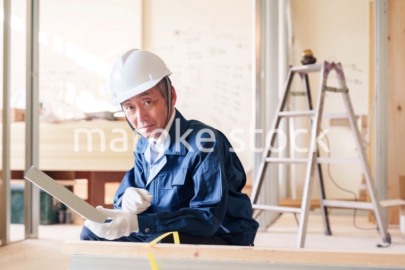 建設現場で軽量鉄骨の確認をする男性の職人