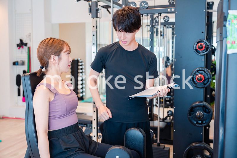パーソナルジムに通う女性とトレーナー