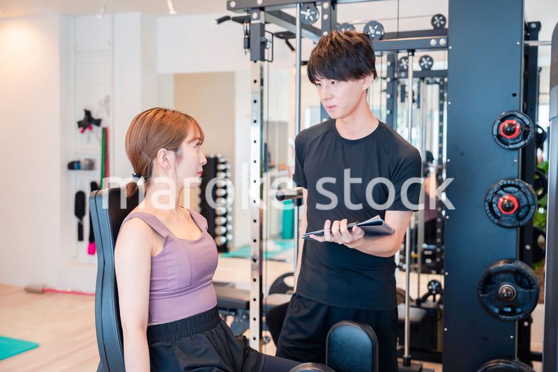 パーソナルジムに通う女性とトレーナー