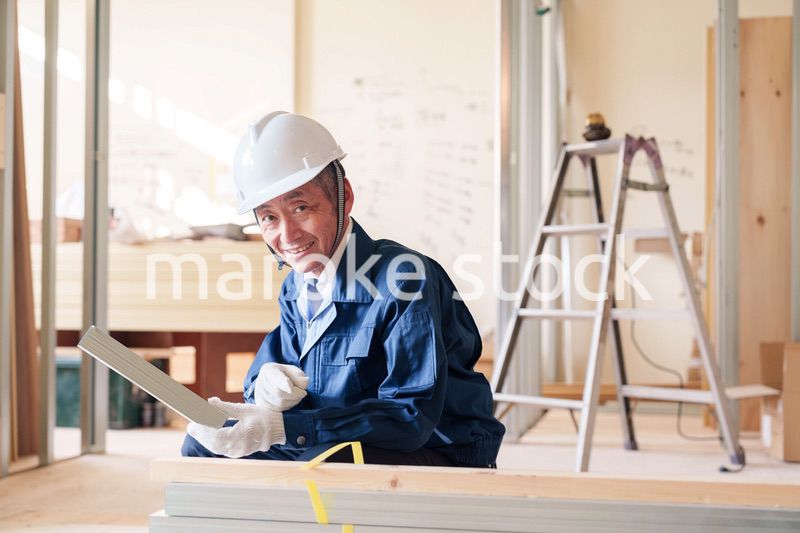 建設現場で軽量鉄骨の確認をする男性の職人