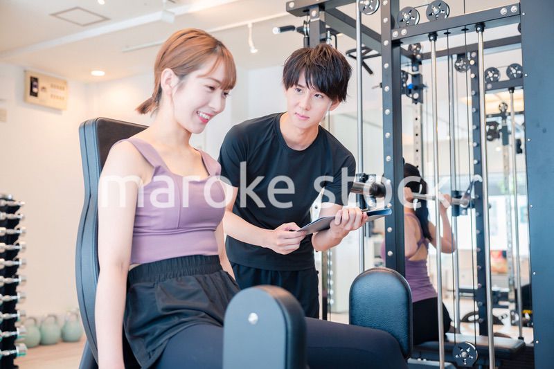 ジムのマシーンでトレーニングをする人