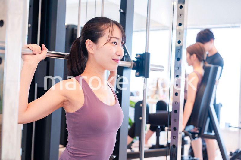 ジムのマシーンでトレーニングをする人