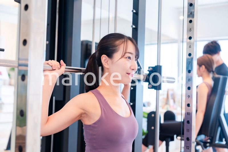 ジムのマシーンでトレーニングをする人