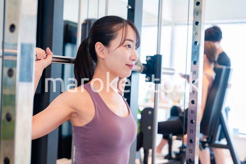 ジムのマシーンでトレーニングをする人
