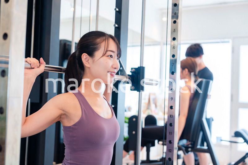 ジムのマシーンでトレーニングをする人