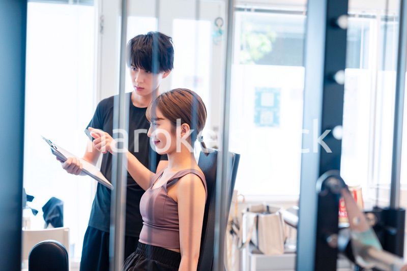 パーソナルジムに通う女性とトレーナー