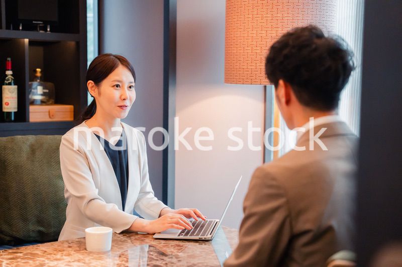 ホテルのラウンジでビジネスミーティングをする人々