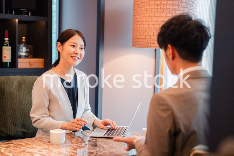 ホテルのラウンジでビジネスミーティングをする人々