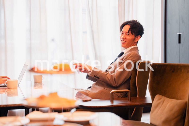 ホテルのラウンジでビジネスミーティングをする人々