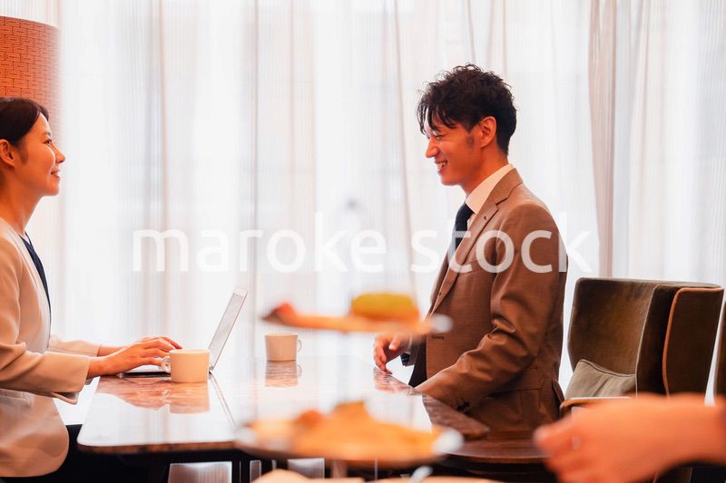 ホテルのラウンジでビジネスミーティングをする人々