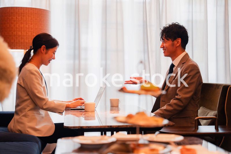 ホテルのラウンジでビジネスミーティングをする人々