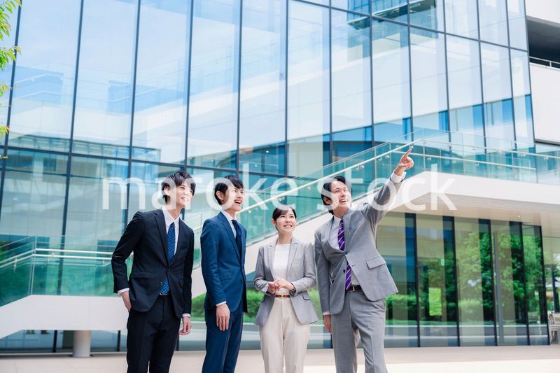 笑顔で未来を指差すビジネスパーソン