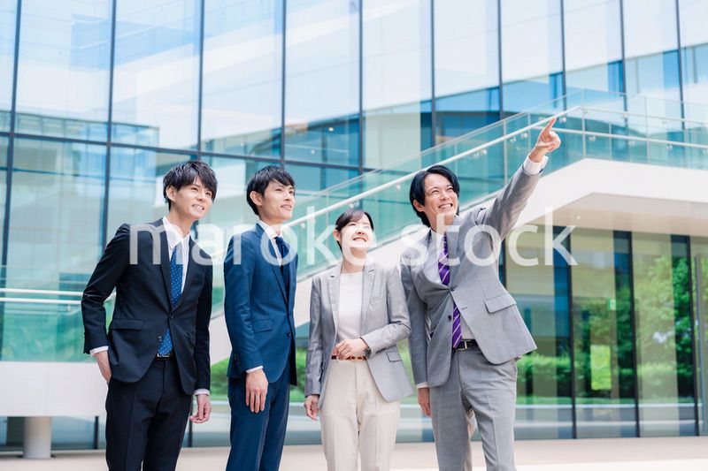 笑顔で未来を指差すビジネスパーソン