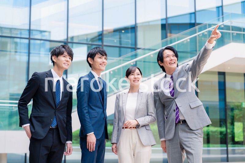 笑顔で未来を指差すビジネスパーソン