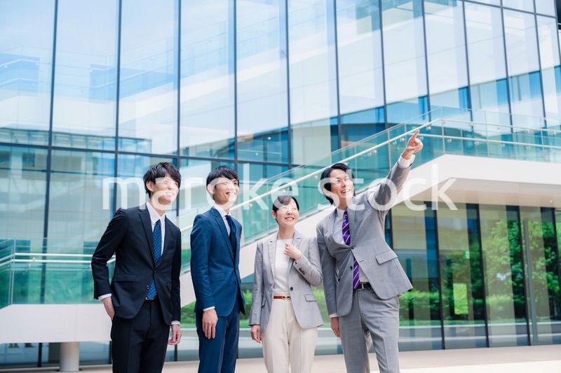 笑顔で未来を指差すビジネスパーソン