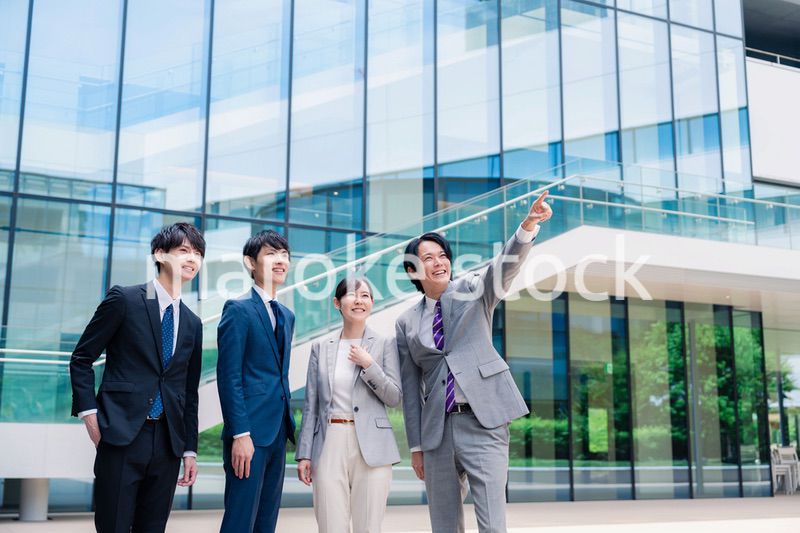 笑顔で未来を指差すビジネスパーソン