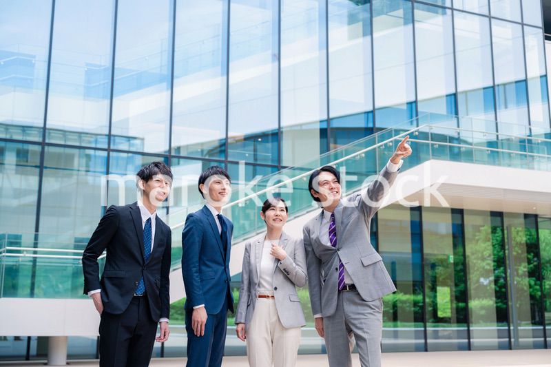 笑顔で未来を指差すビジネスパーソン