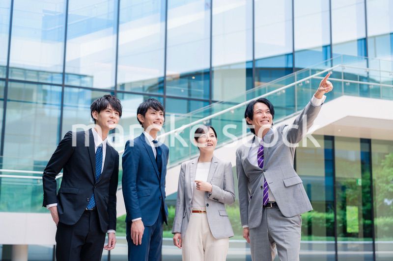 笑顔で未来を指差すビジネスパーソン