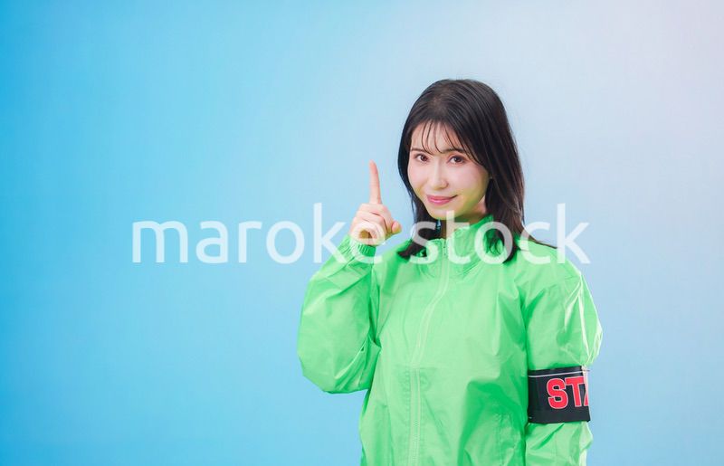 笑顔でお客様を案内するイベントスタッフ（水色背景）