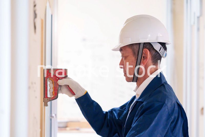 タッカーで建築資材を固定する男性の職人