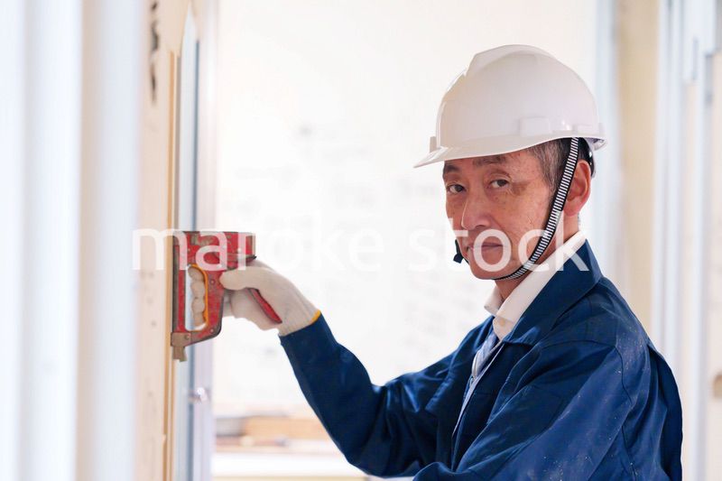 タッカーで建築資材を固定する男性の職人