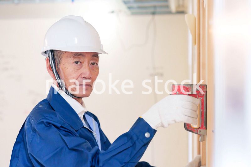 タッカーで建築資材を固定する男性の職人