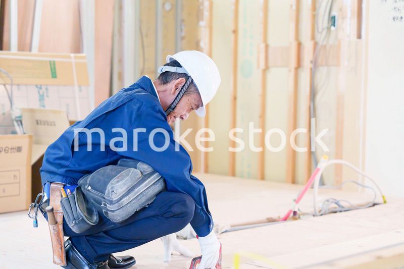 タッカーで建築資材を固定する男性の職人