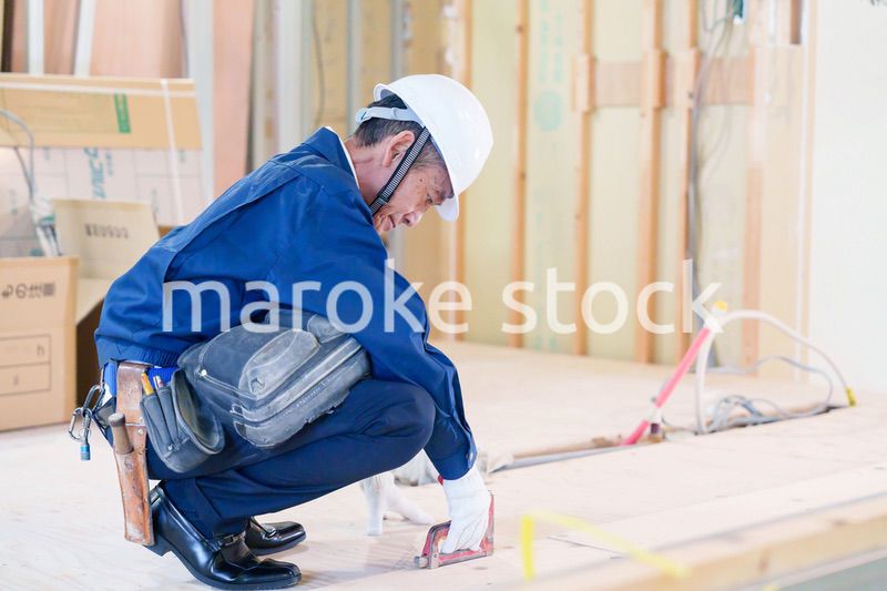 タッカーで建築資材を固定する男性の職人