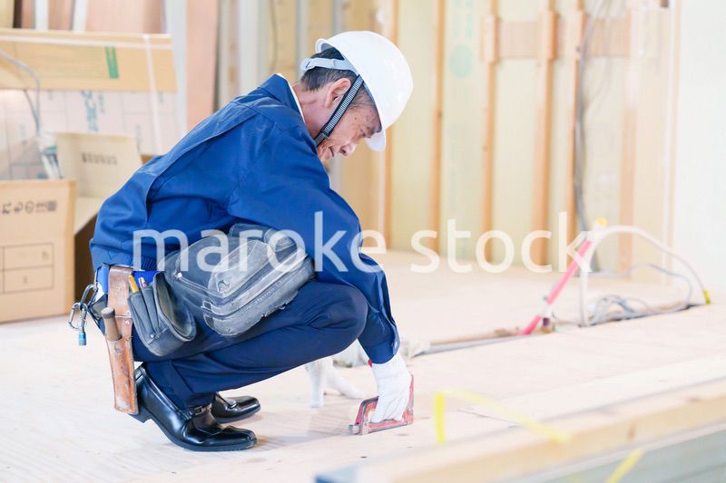 タッカーで建築資材を固定する男性の職人