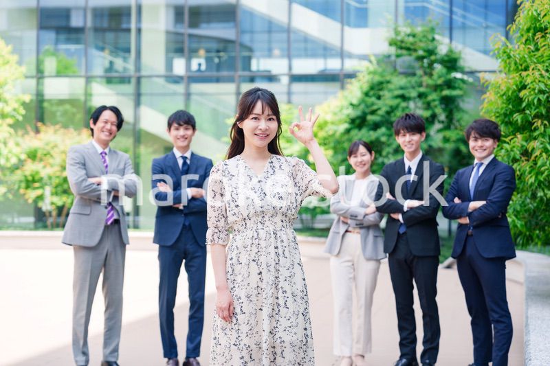 オフィス街に立つ若い女性キャリアウーマンとスタッフ